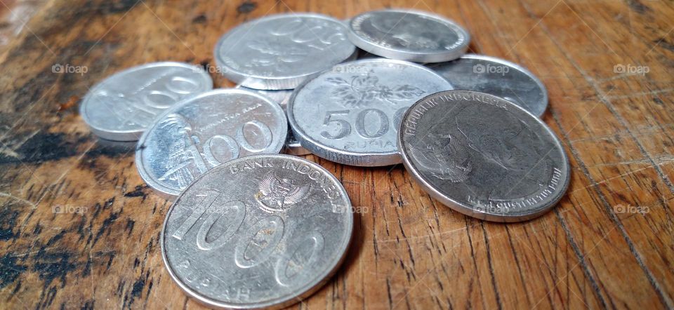 Rupiah coins on an ancient wooden table