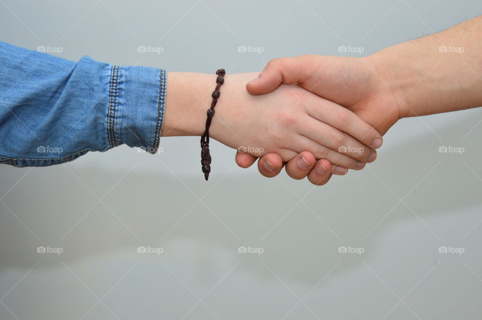 Close-up of holding hands against grey background