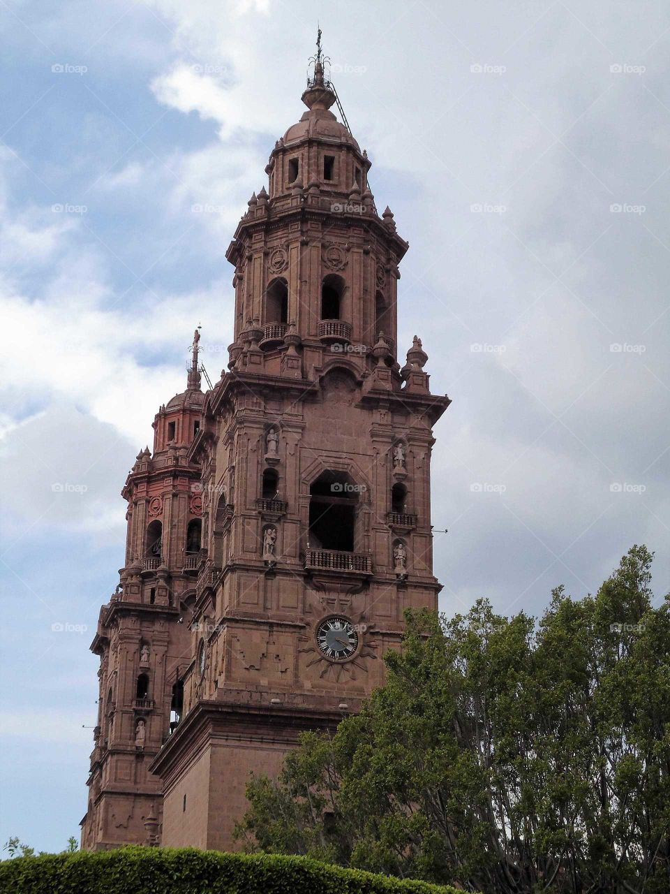 towers of the Morelia Cathedral against a clouded sky