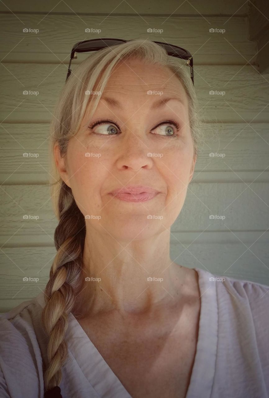 Blond woman with a braid looking sideways with a smile