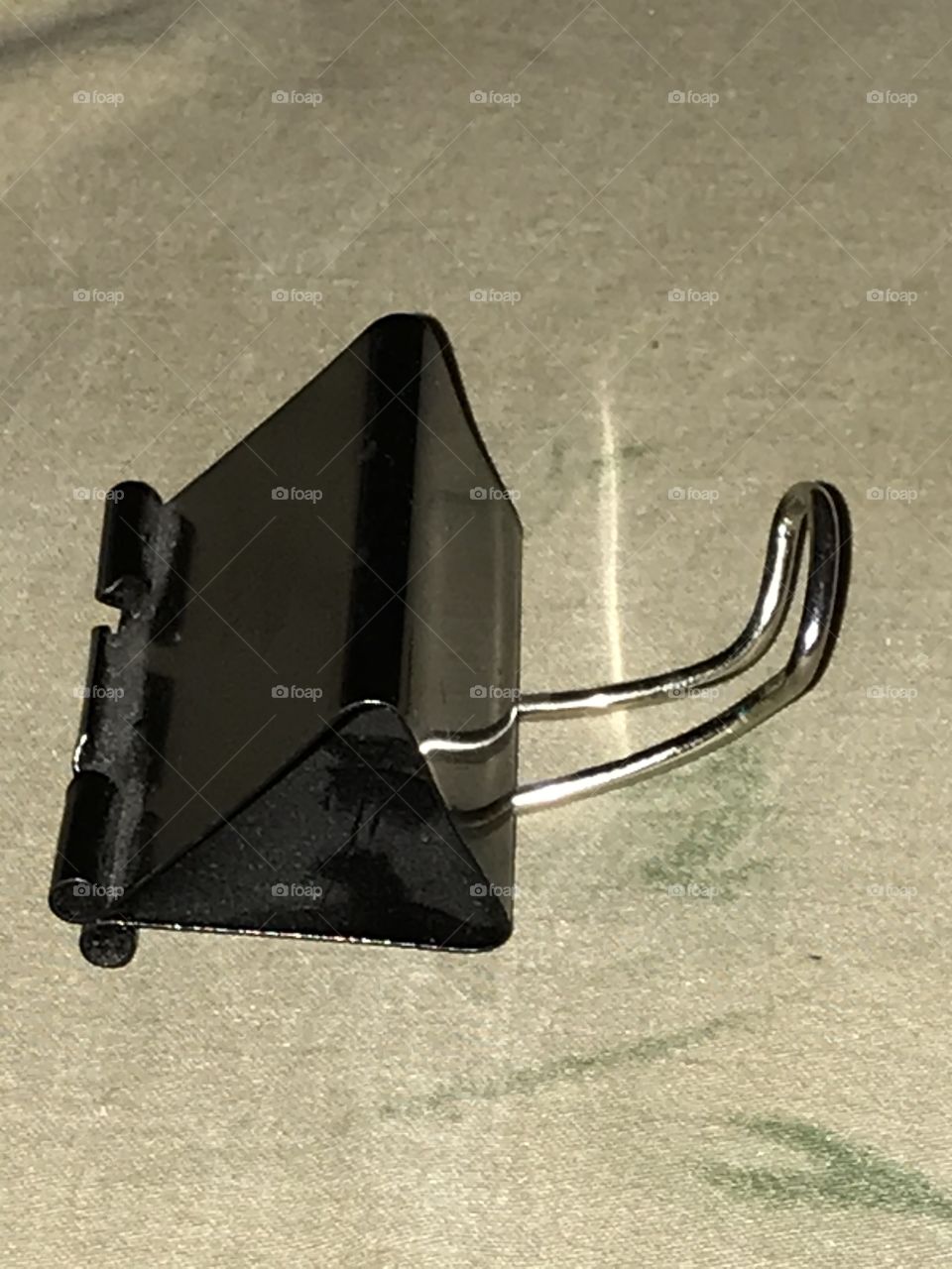 A homemade smartphone stand. It is made from a binder clip.