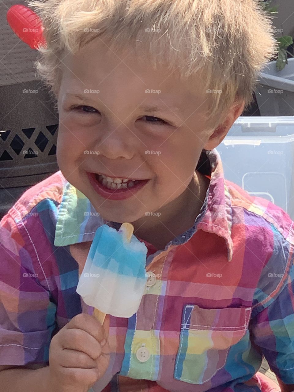 My son eating a popsicle on the deck 