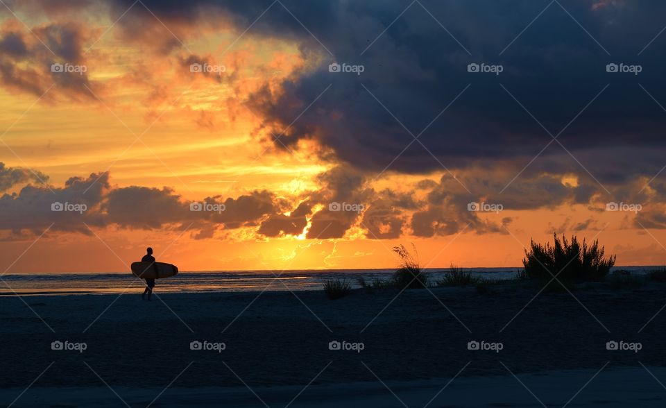 Surfer on the beach at Saint Simons Island  ready to catch the first wave. 