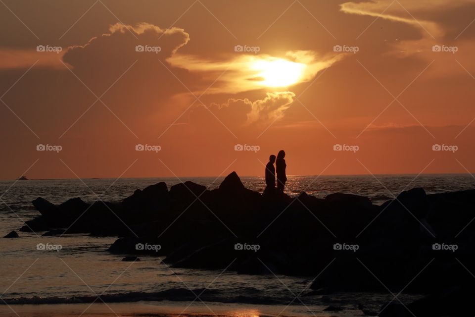 Lovers looking at sunrise orange skies
