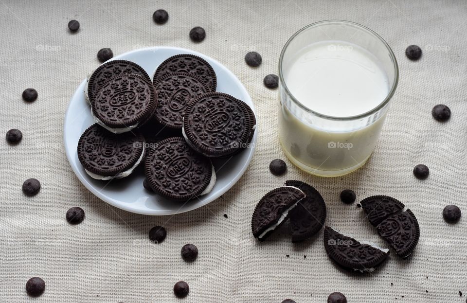 a glass of milk and oreo cookies