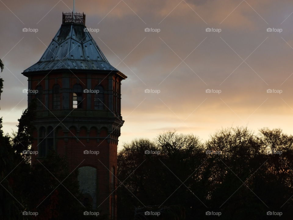 Water tower in front of sunset