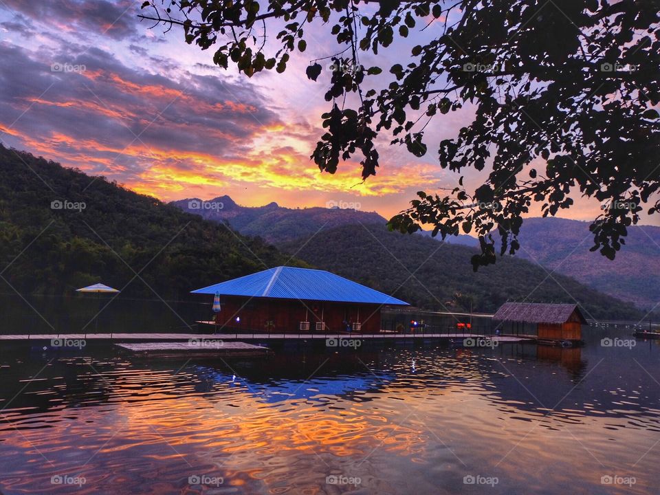 Orange light, mountain evening, water reflection, houseboat as a shelter, dam