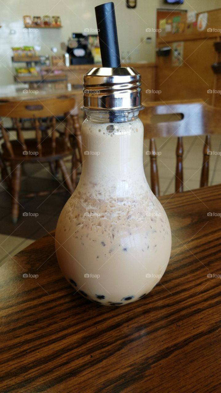 Refreshing milk tea boba drink in a light bulb container