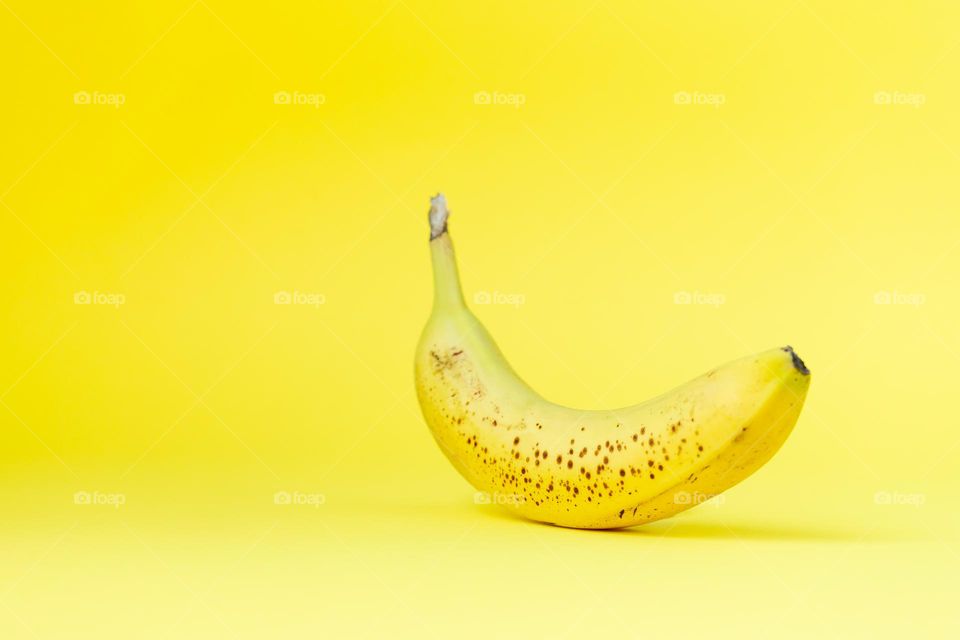 Yellow banana on yellow background