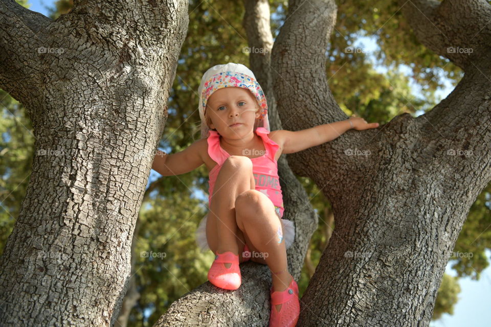 girl in a pink swimsuit on a tree