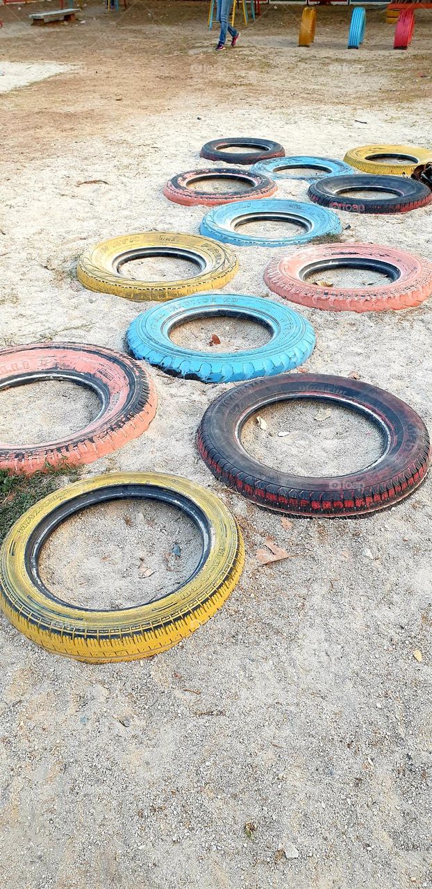 Playground, colored rubbers in the sand, circles, games for children.