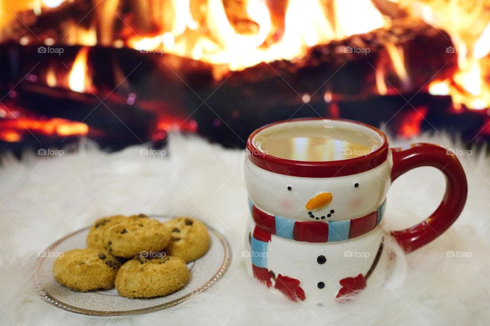 cappuccino with biscuits in front of the fireplace