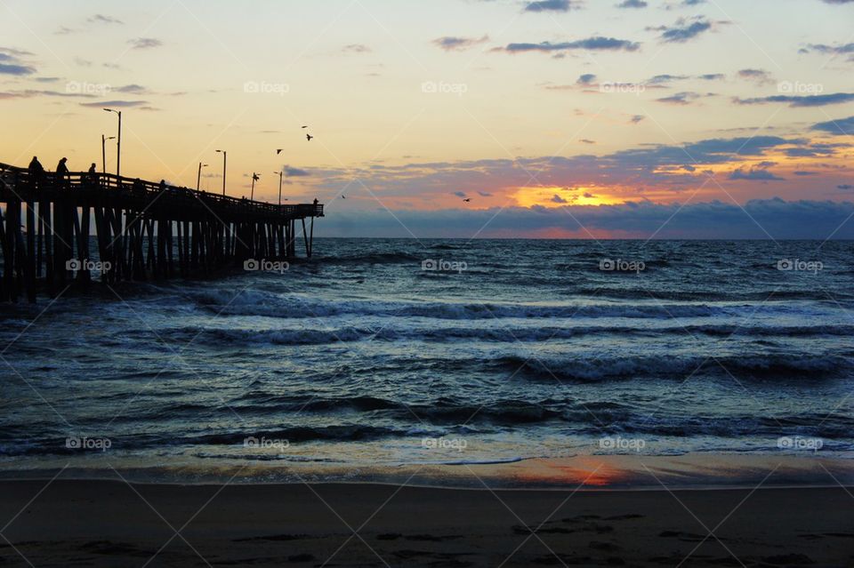 Pier over sea at sunrise