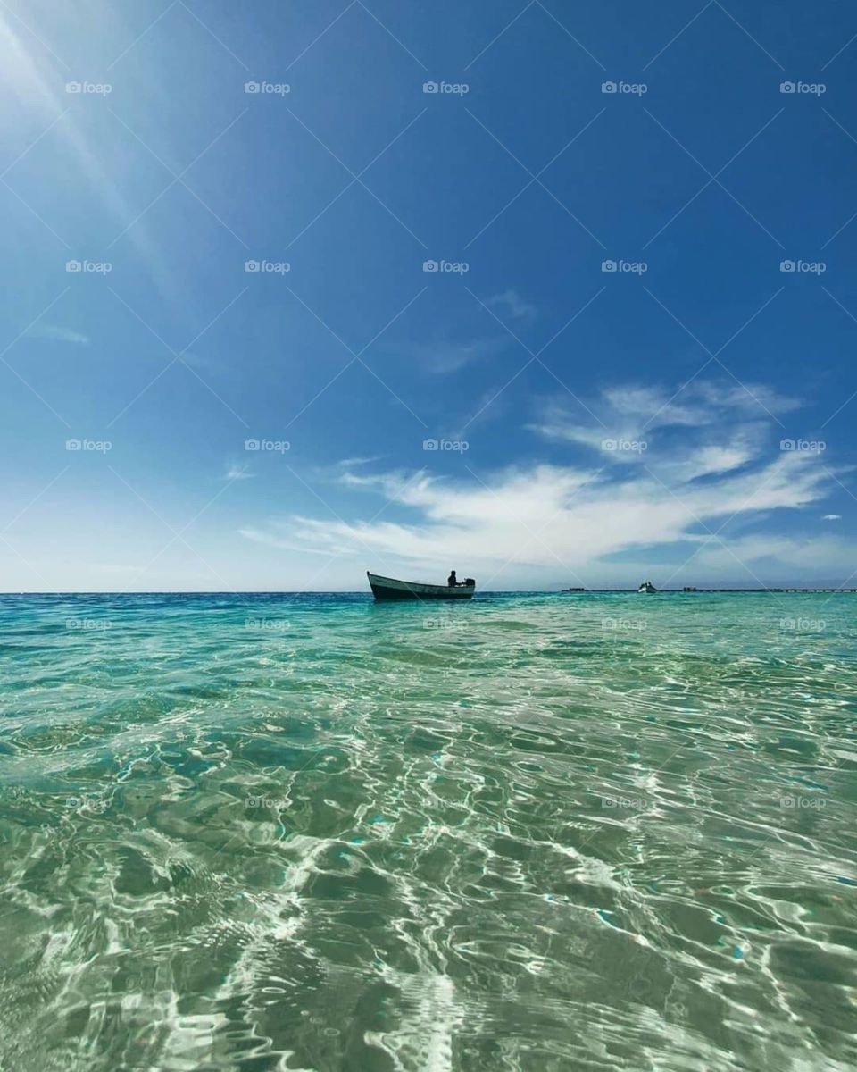 A colourful sea (water) with a ship