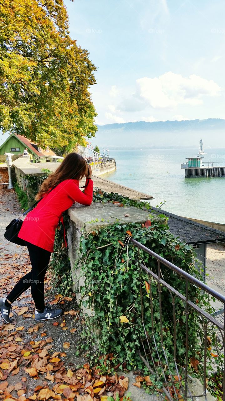 A lady is taking the photo of the fogy lake in Lindau, Germany.