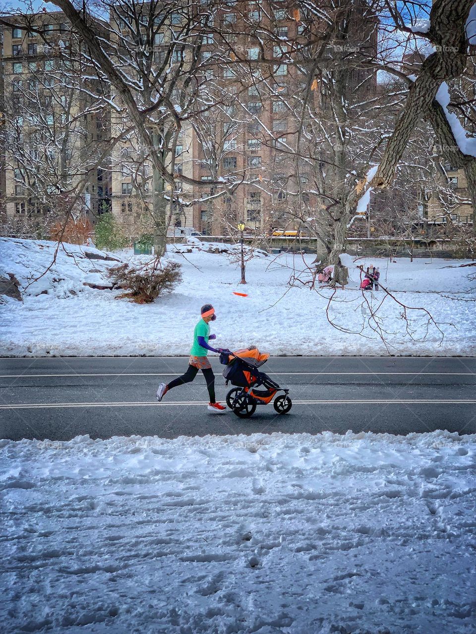 A man who jog while pushing a stroller. 