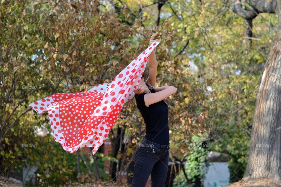 Beautiful Young Woman Dancing with Scarf Outside in Nature