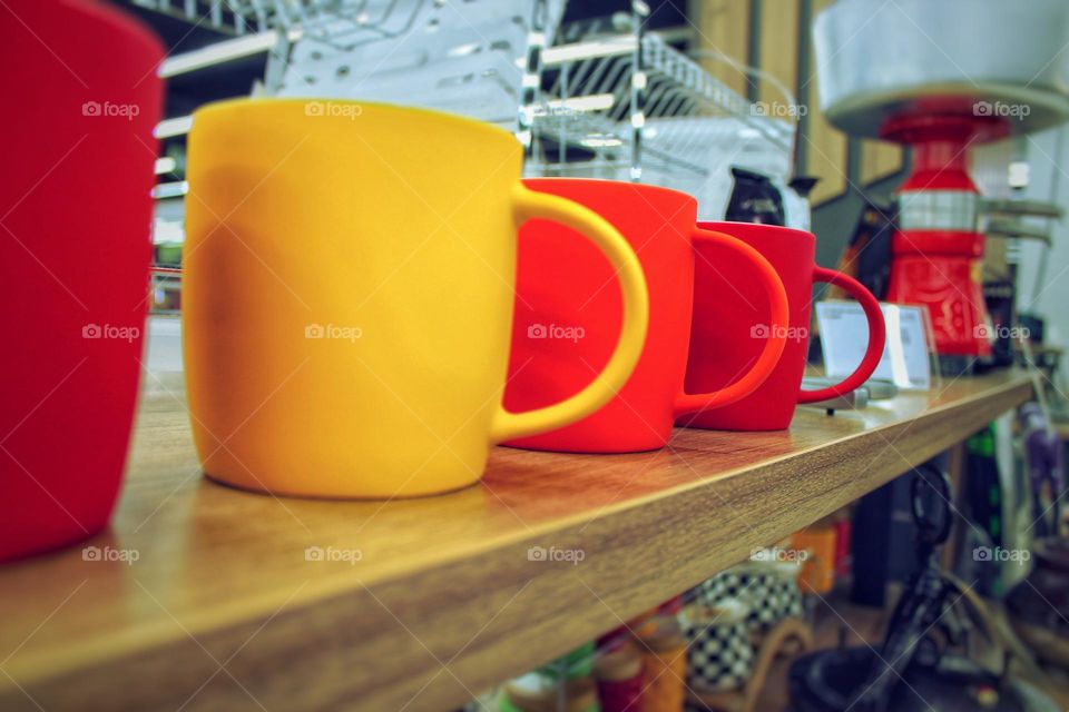 colored bright mugs on the bar counter of the cafe give a good mood to visitors