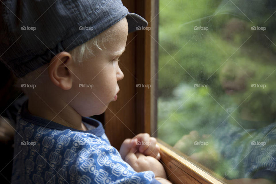 Little boy looking out on the train