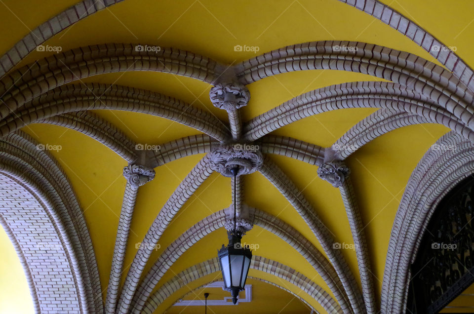 Low angle view of yellow ceiling with architectural ornate features in Budapest, Hungary.