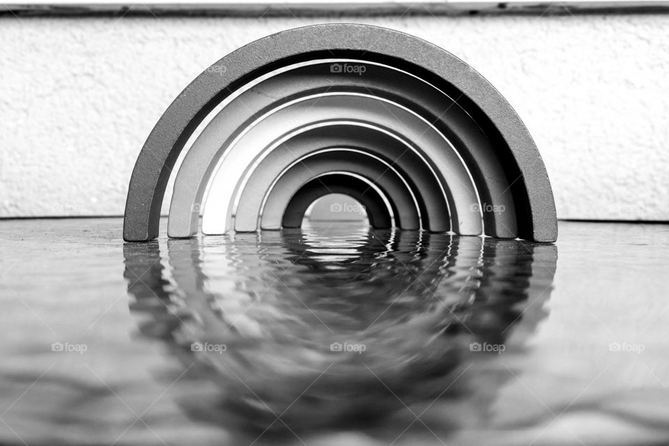 Wooden semicircles and their reflection on the glass table