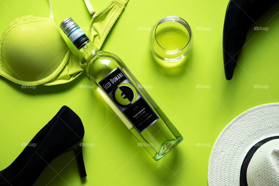 Flat lay of a bottle of Ecco Domani wine and scattered clothing items 