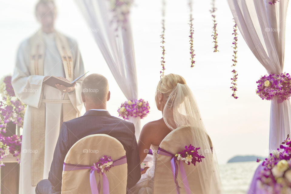 Bride and groom beach wedding. ceremony with the priest