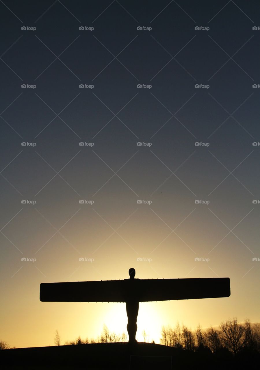 The Angel Of The North statue at sunrise and with a cloudless, clear sky.