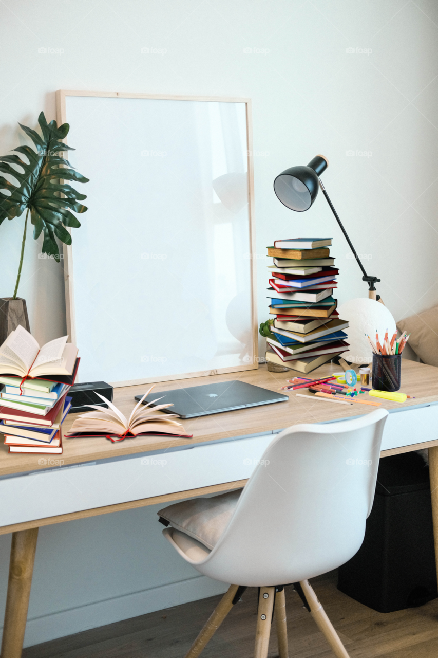 working desk photo with so many books and laptop with beautiful green plants