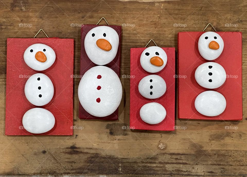 Handmade stylized snowmen with painted stones and pebbles for a unique Christmas souvenir