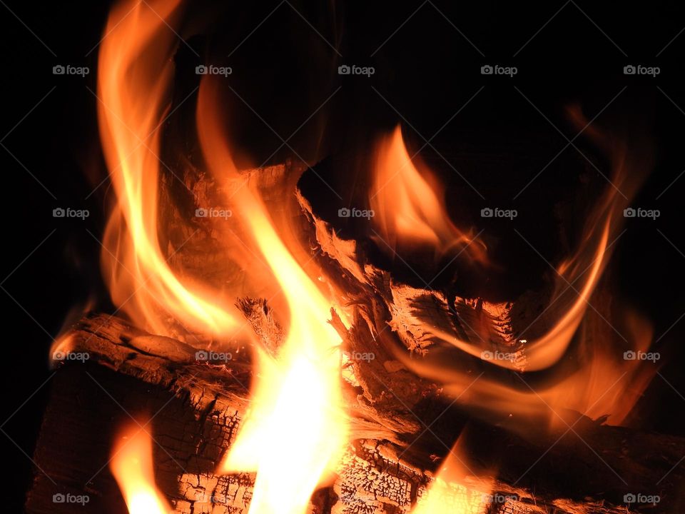 Beautiful wonders and colors in the flames with soft looking of a bonfire warming up the people in the late evening night of the fall season.