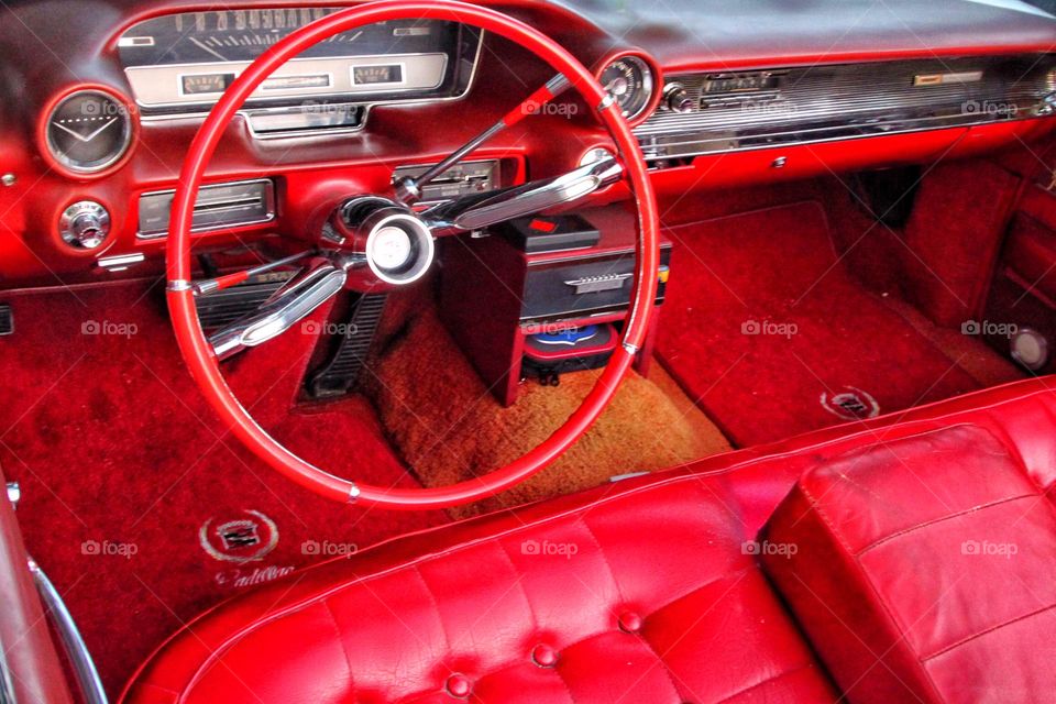 View from above into a bright red Cadillac with red leather seats, carpets and steering wheel