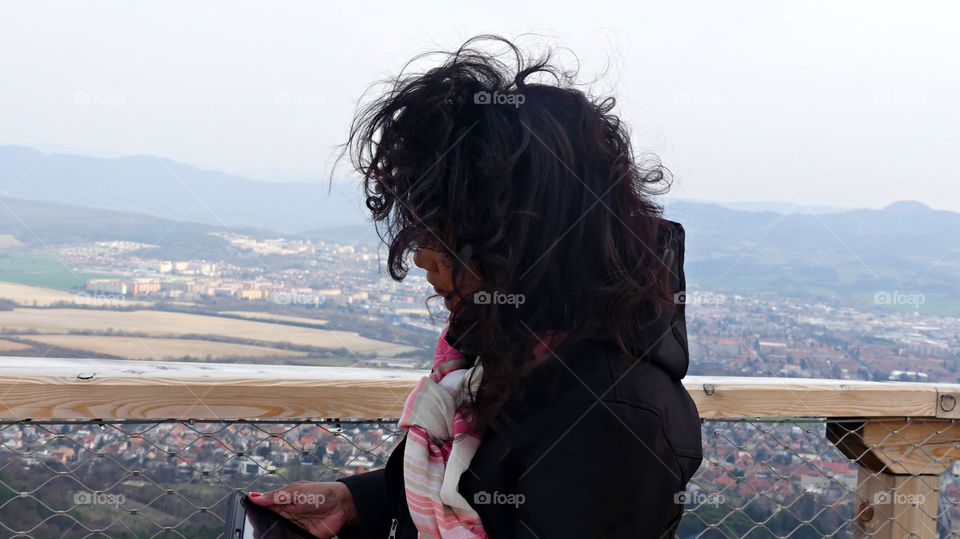 Glimmers: Small Moments of Happiness  - A women’s hair blows in the wind while reviewing phone photos 