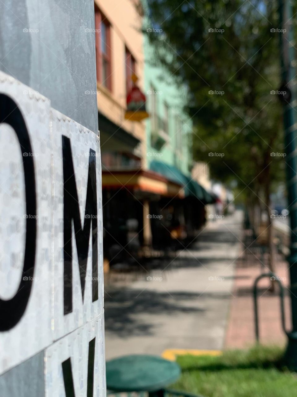 Historical downtown area with architectural businesses buildings on a quiet central eastern Florida street with a focus on lettering on a corner street metal pole.