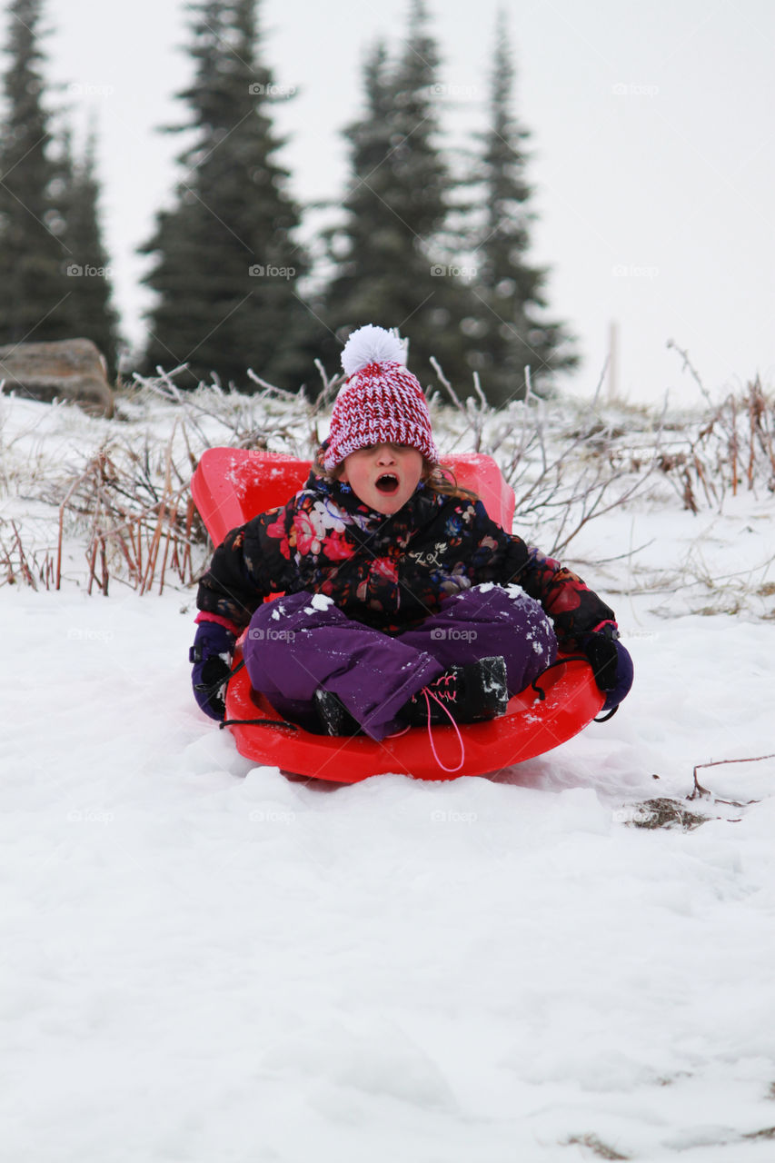 Child sledding down a hill