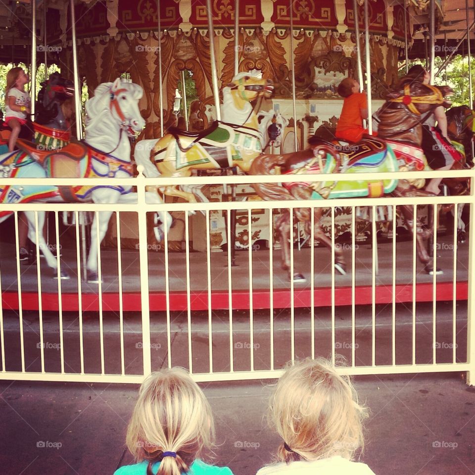 Watching the Carousel. Two sweet little girls waiting their turn to ride