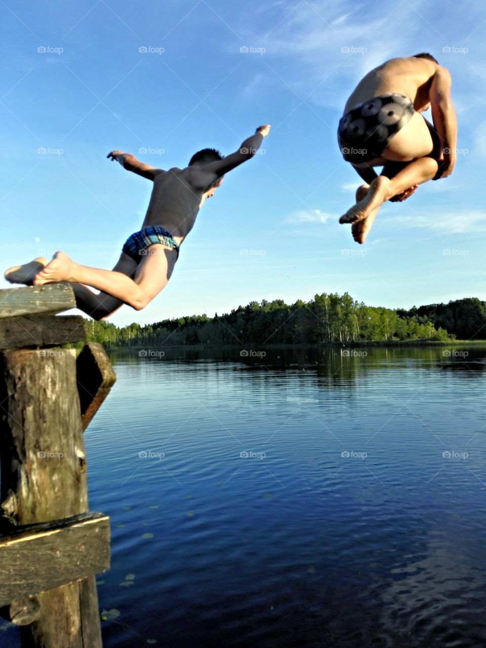 Two boys jump into the water