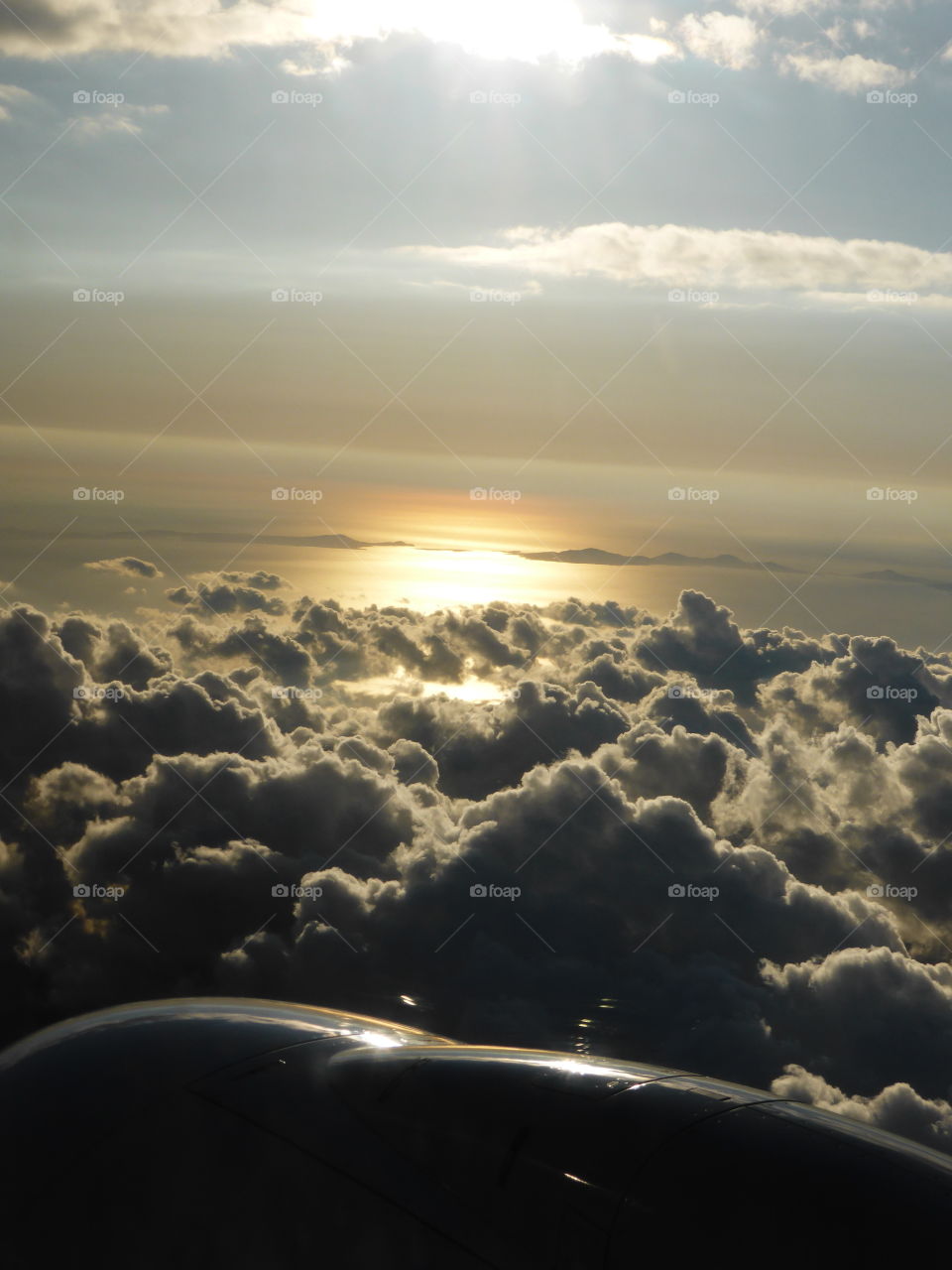 view from a plane, sunset seen over the clouds
