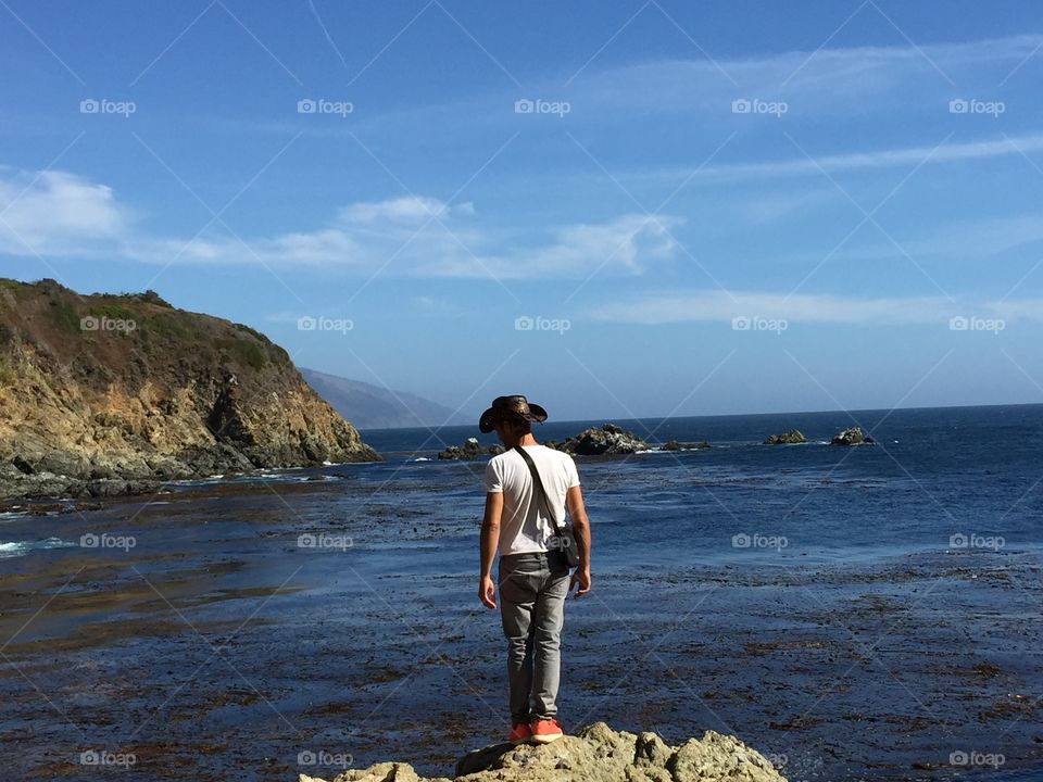 Man stands on the rock at the sea