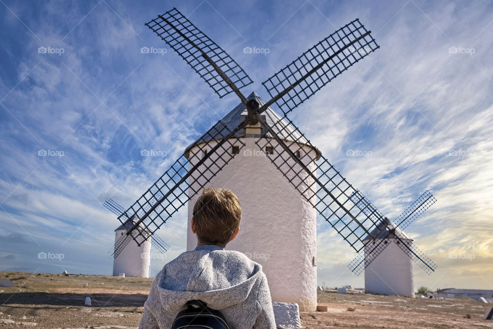 Tourist woman looks at three traditional windmills in Spain
