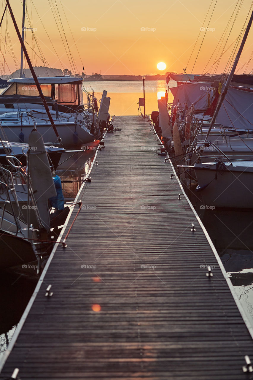 Yachts and boats moored in a harbour at sunrise. Candid people, real moments, authentic situations