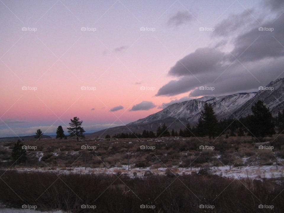 Pink Evening sky after snow. Dusk setting in on snow sprinkled hills