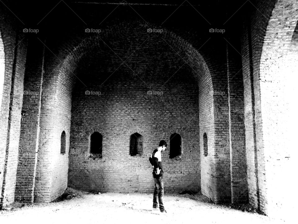 person standing in a room of an ancient architectural placr