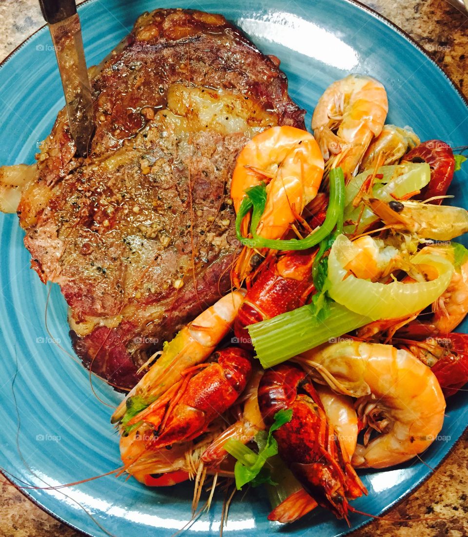 Surf n turf. Grilled ribeye with boiled crawdads and shrimp. Accented by celery and onions for color and flavor!
