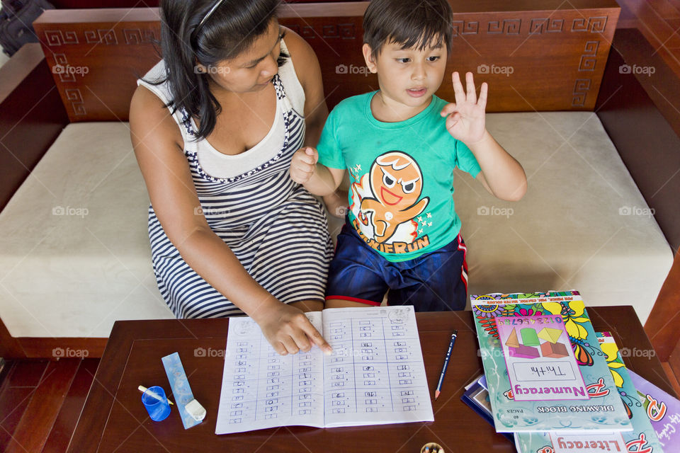 mother helping  kid with homework