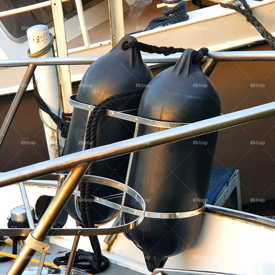 Two black fenders.  on a boat