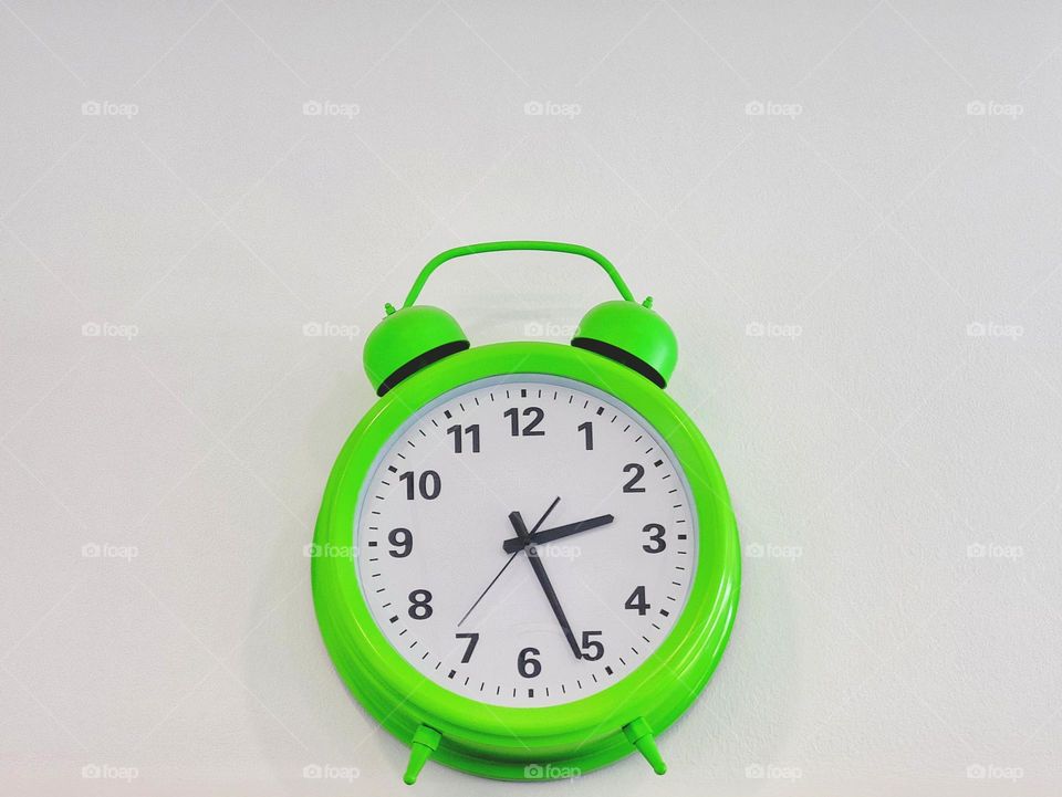 Green clocks at the white wall