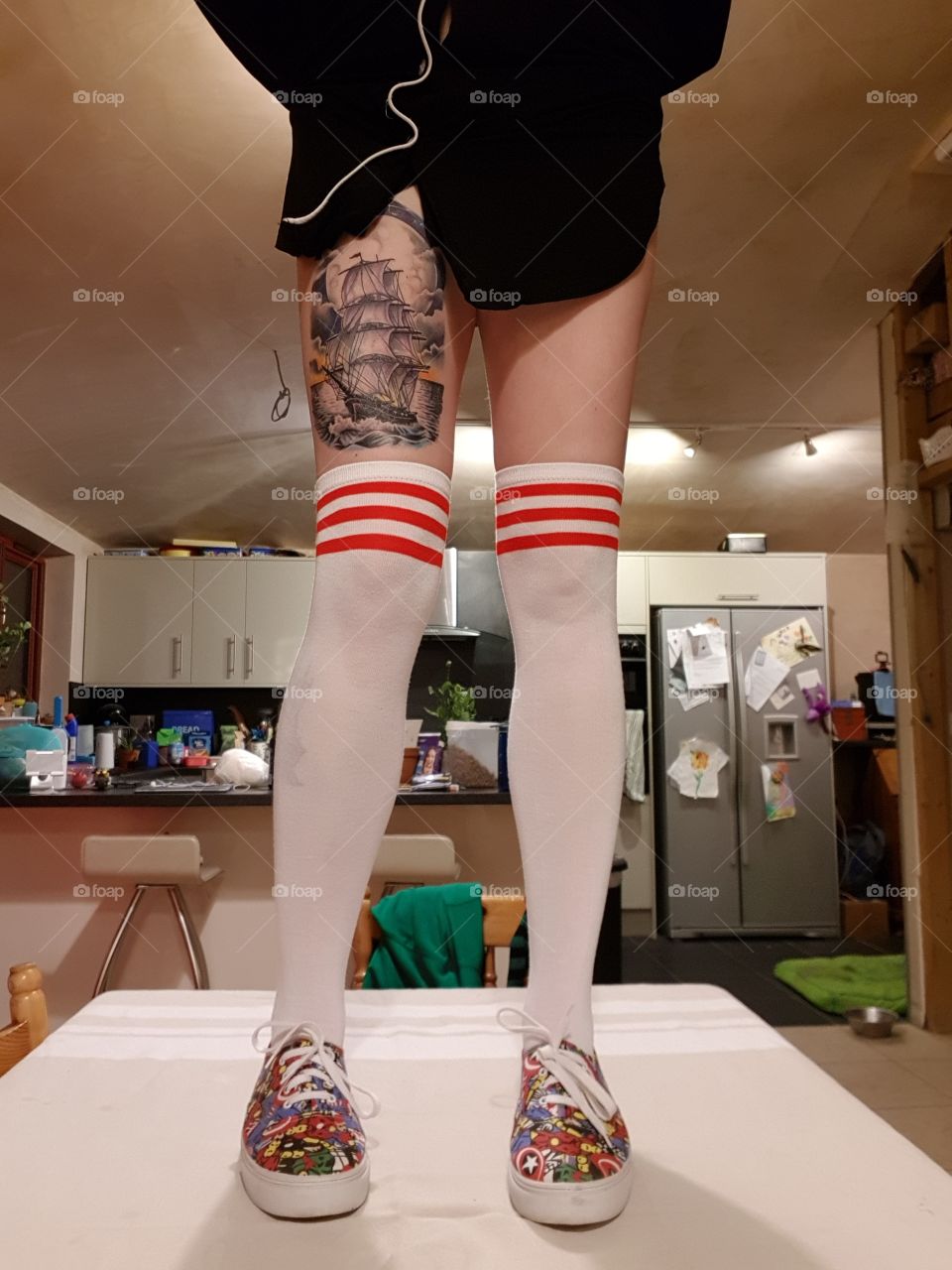 long legs, tube socks, tattooed woman, standing on the table no f@#ks given.