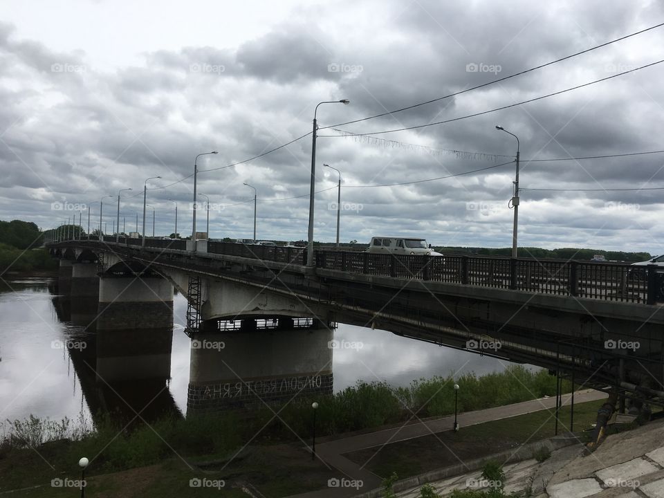 Мост через реку в городе в непогоду на небе дождевые облака