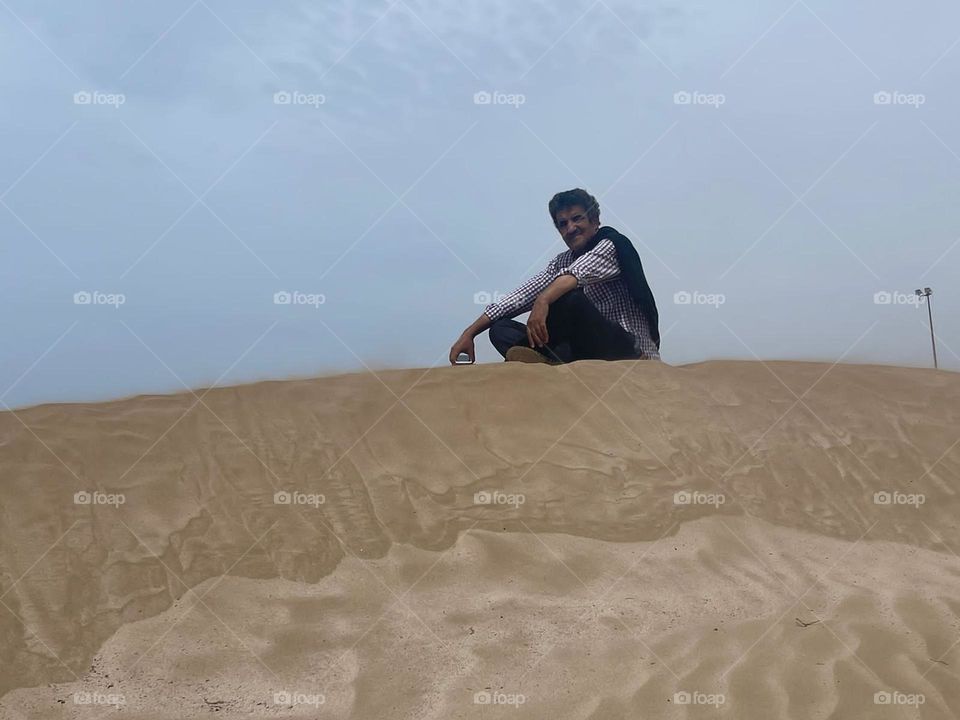 I m sitting on the sand.